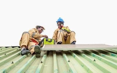 two workers in PPE on a roof